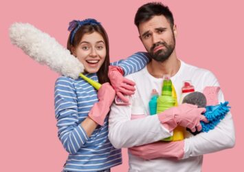 glad attractive woman has toothy smile leans shoulder handsome displeased man holds brush 1