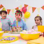 birthday boy blowing candle with his friends 23 2148046249